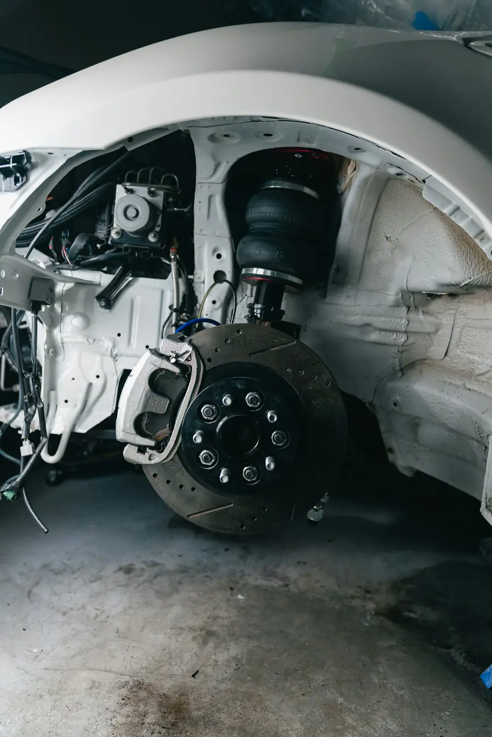 Wheel off a car showing the suspension and brake assembly